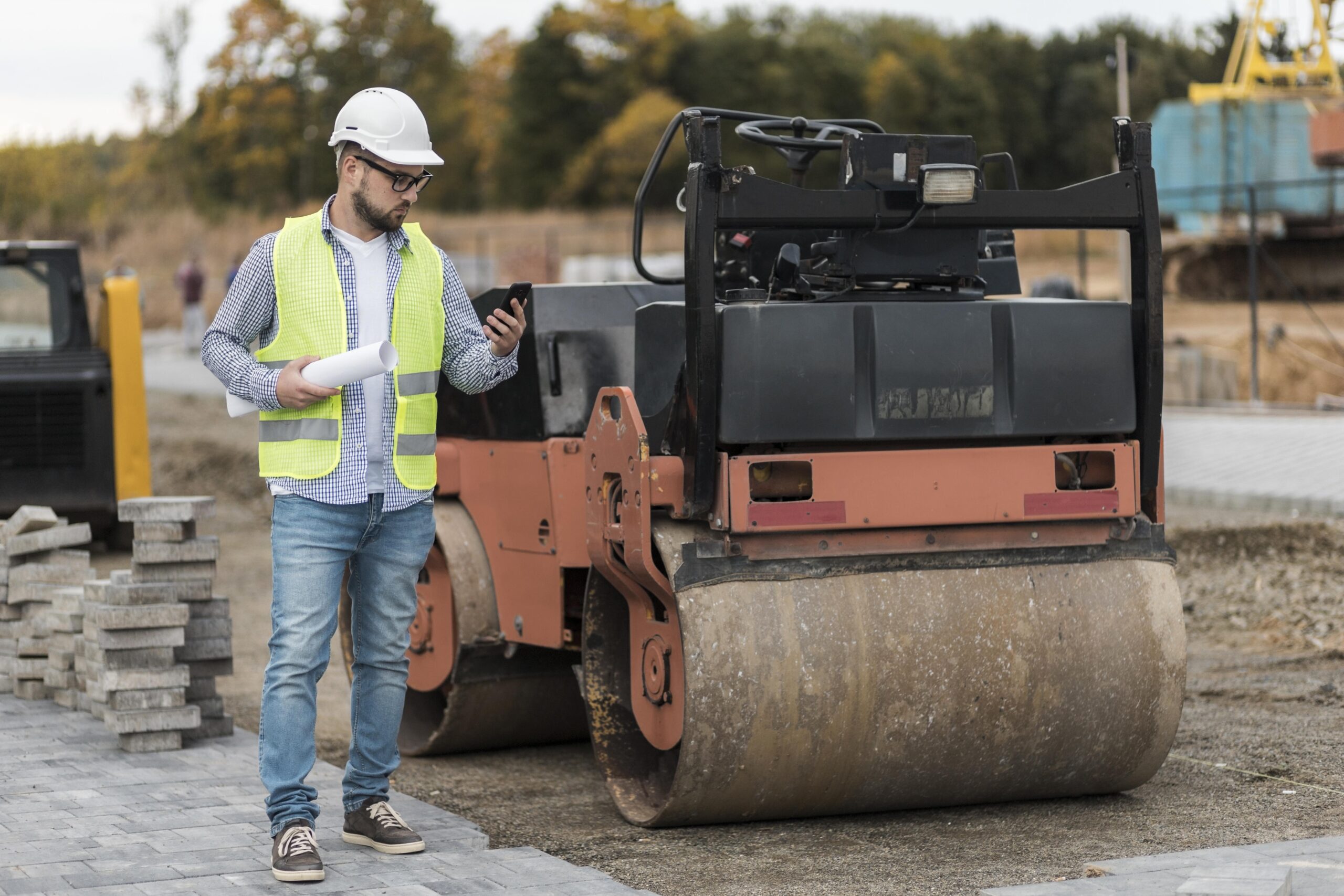 un homme a coté d'un compacteur a rouleau