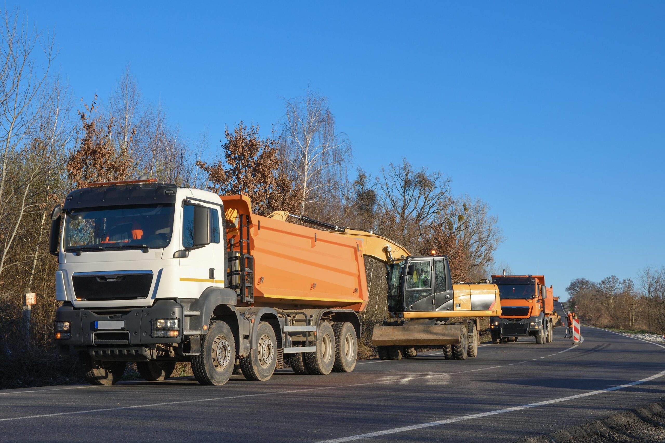 Camion benne et un autre engin de chantier stationnés.