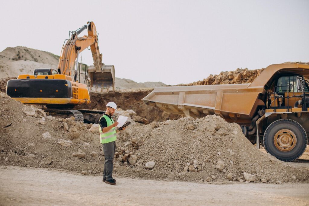 Un chantier de terrassement dynamique où un puissant engin de chantier est en action, creusant et nivelant le terrain avec précision.