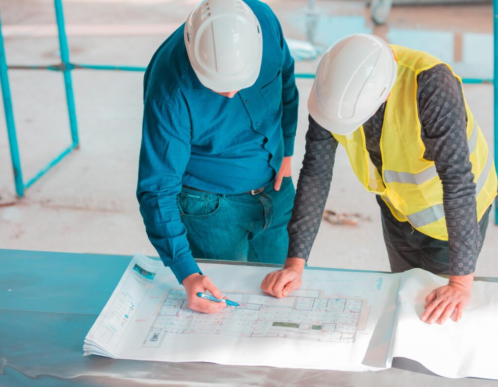 Deux ingénieurs examinent des plans implantation bâtiment